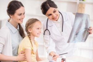 Doctor-communicating-with-child-with-autism-and-caregiver-at-the-hospital