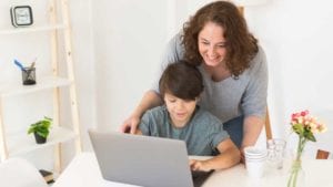 Mother-helping-son-at-home-during-teletherapy-with-speech-language-pathologists-during-telepractice