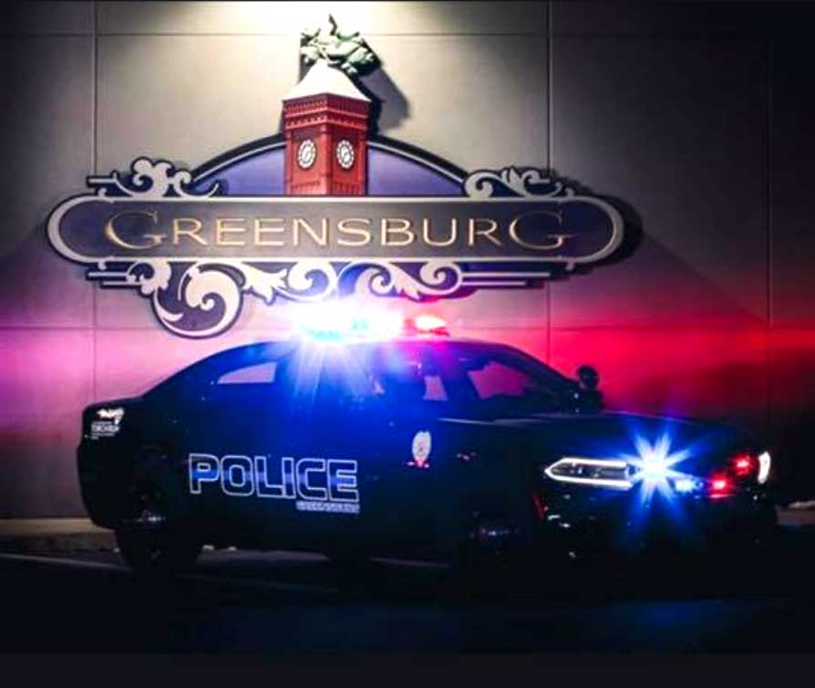 Greensburg Police car in front of Town sign