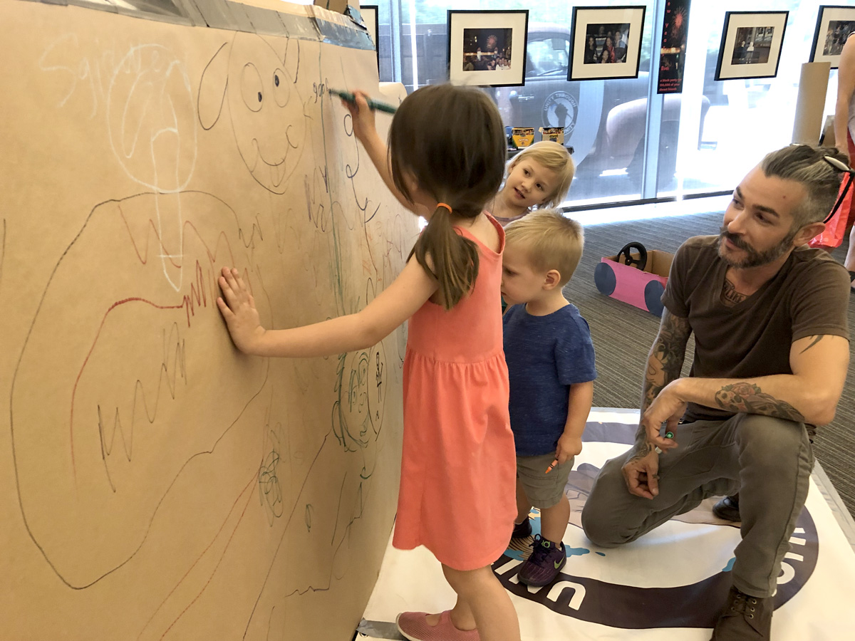 kids drawing on paper wall at Tempe Public Library