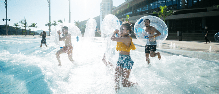 group running into the big wave pool area