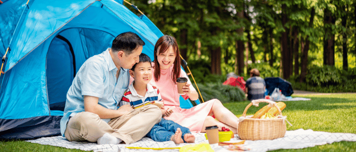 An Asian family of three having a picnic in the park.