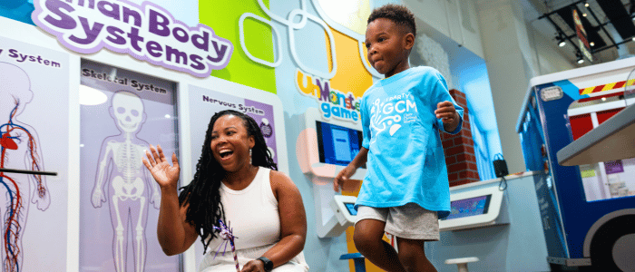 Two individuals interacting at a colorful human body educational exhibit.