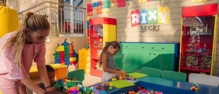 Children and an expert playing with Leo at Brixy Bricks in Rixos Hotel the Palm Dubai