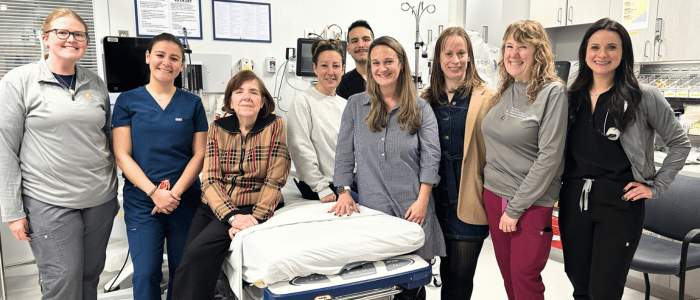Atlantic Health Morristown Medical Center Gagnon Pediatric Emergency Department A group of healthcare professionals pose together in a medical setting, with medical equipment and a bed visible in the background.