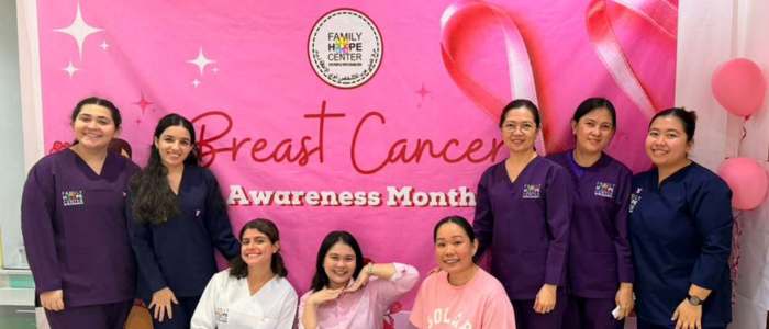 Family Hope Center (1) Family Hope Center posing in-front of a Breast Cancer Awareness backdrop