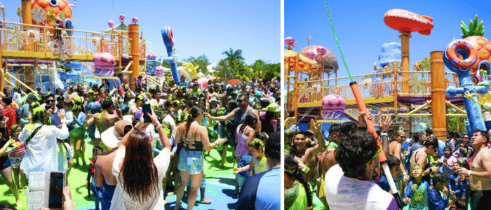 _AquaNick™ Riviera Maya (2) Crowded outdoor water park party with colorful slides, tropical decorations, and people dancing under a bright blue sky.